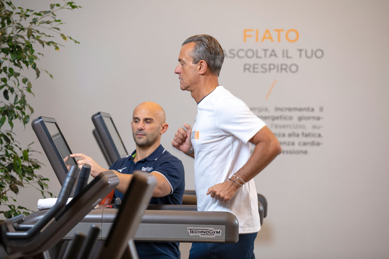 Hombre corriendo acompañado de su entrenador personal
