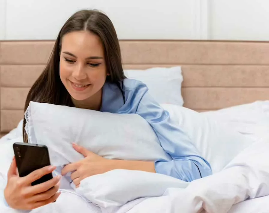 mujer enviando mensajes desde la cama antes de dormir
