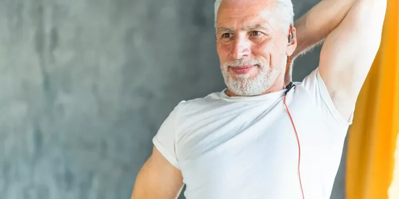 hombre de 50 años felices haciendo estiramientos en el gimnasio