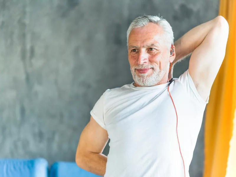 hombre de 50 años felices haciendo estiramientos en el gimnasio